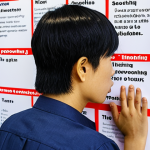 ** A person looking thoughtfully at a flowchart or Ishikawa diagram filled with Vietnamese words, brainstorming solutions to a problem. The setting is a modern, bright co-working space in Ho Chi Minh City. Focus on the individual's determined expression.

**